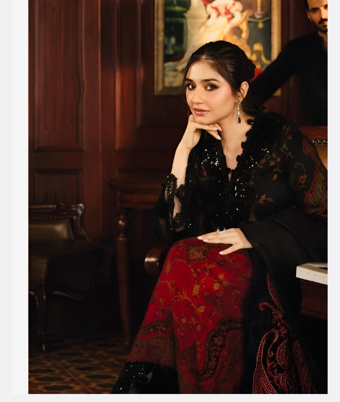 Woman wearing luxury black and maroon embroidered chiffon suit with sequin dupatta showcasing Pakistani formal wear for weddings and parties
